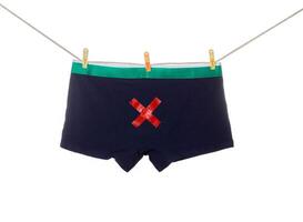 Men's underpants hang on a clothesline with a red cross on a white background. Sexually Transmitted Infectious Disease Concept in Men, isolate photo