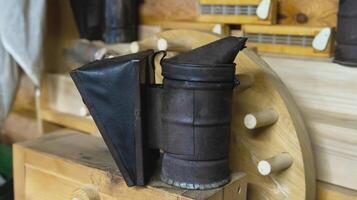 smoker for bees on a wooden background. Breeding bees and extracting honey. photo