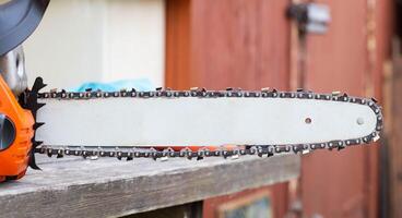 wear and tear of the chain on the chainsaw bar. Chain adjustment and tension. Copy space for text photo