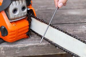 chainsaw chain sharpening with a special file. Dulling an old chain on a chainsaw bar. Industry photo