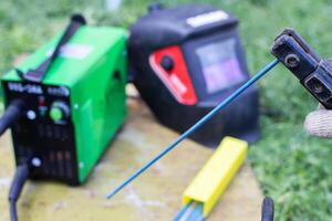 Welding machine, resistance seam welding electrodes and welding mask. The concept of services of a welder, the cost of welding work and safety. photo