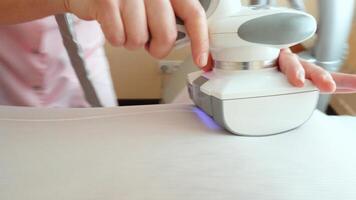 A specialist girl in a beauty salon makes a modern procedure for a fat man to reduce excess weight, restore skin density and elasticity. Apparatus massage LPG, vacuum roller machine photo