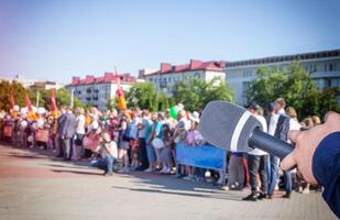 The microphone on the background of a crowd of people in the square concept of freedom of speech and interview. Rally on the square, strike, copy space, public opinion photo