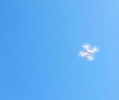 White quadcopter takes photos and shoots in the sky, copy space, drone