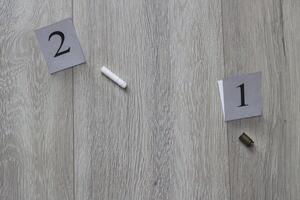 A cartridge case and a cigarette butt lie on a wooden background, close-up, evidence and investigation photo