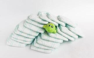 Baby diapers on a white background and a children's toy frog photo