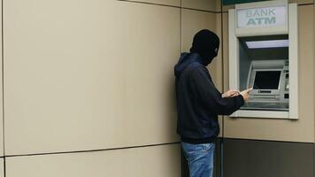 Hacker or thief with smartphone steals information or data from bank ATM photo
