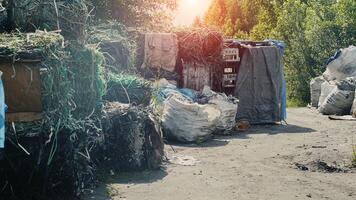 Large mountains of extruded polypropylene and cellophane against a sunset, processing and sorting garbage, industrial photo