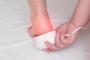 Treatment of heel spurs and removal of inflammation on the heel with a magnet treatment, physiotherapy, white background, close-up, copy space photo
