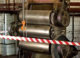 Production equipment rollers are fenced with protective tape, an investigation is underway, an incident, an industrial accident, danger, workshop photo