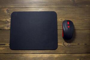 Computer mouse pad and mouse on a wooden background photo