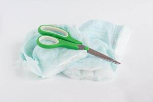 Sliced child pampers and scissors on a white background, diapers photo