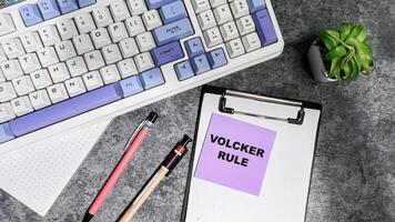 Concept of Volcker Rule write on sticky notes isolated on Wooden Table. photo