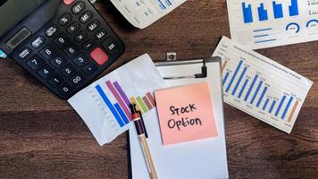 Concept of Stock Option write on sticky notes isolated on Wooden Table. photo