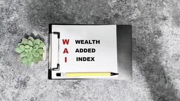 Concept of WAI - Wealth Added Index write on paperwork isolated on Wooden Table. photo