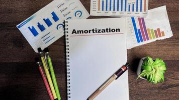 Concept of Amortization write on book isolated on Wooden Table. photo