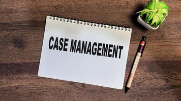 Concept of Case Management write on book isolated on Wooden Table. photo