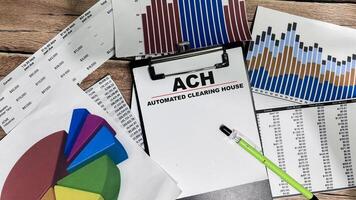 Concept of ACH - Automated Clearing House write on paperwork isolated on Wooden Table. photo