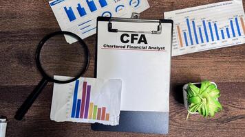 Concept of CFA - Chartered Financial Analyst write on paperwork isolated on Wooden Table. photo