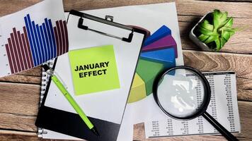 Concept of January Effect write on sticky notes isolated on Wooden Table. photo