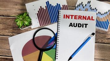 Concept of Internal Audit write on book isolated on Wooden Table. photo
