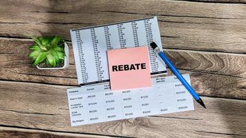 Concept of Rebate write on sticky notes isolated on Wooden Table. photo