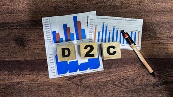 Concept of The wooden Cubes with the word D2C on wooden background. photo