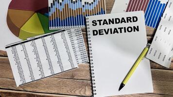 Concept of Standard Deviation write on book isolated on Wooden Table. photo