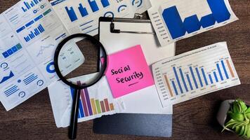 Concept of Social Security write on sticky notes isolated on Wooden Table. photo