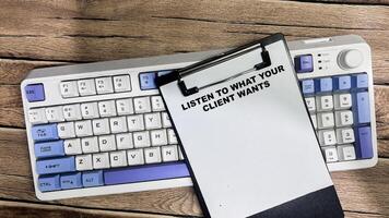 Concept of Listen to What Your Client Wants write on paperwork isolated on Wooden Table. photo