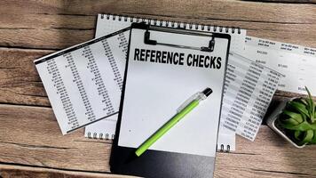Concept of Reference Checks write on paperwork isolated on Wooden Table. photo