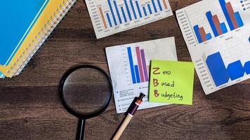 Concept of ZBB - Zero Based Budgeting write on sticky notes isolated on Wooden Table. photo