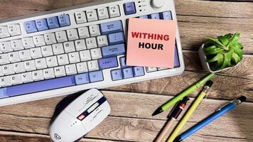Concept of Withing Hour write on sticky notes isolated on Wooden Table. photo