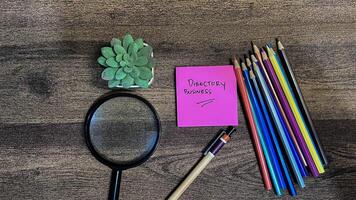 Concept of Directory Business write on sticky notes isolated on Wooden Table. photo