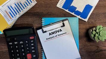 Concept of ANOVA - Analysis of Variance write on paperwork isolated on Wooden Table. photo
