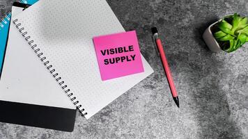 Concept of Visible Supply write on sticky notes isolated on Wooden Table. photo