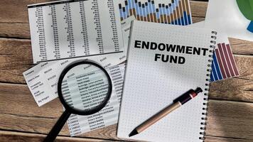 Concept of Endowment Fund write on book isolated on Wooden Table. photo