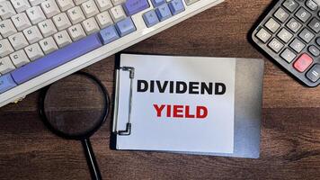 Concept of Dividend Yield write on paperwork isolated on Wooden Table. photo