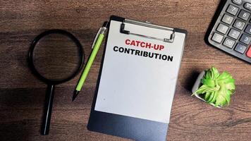 Concept of Catch-up Contribution write on paperwork isolated on Wooden Table. photo
