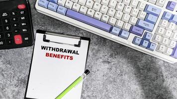 Concept of Withdrawal Benefits write on paperwork isolated on Wooden Table. photo