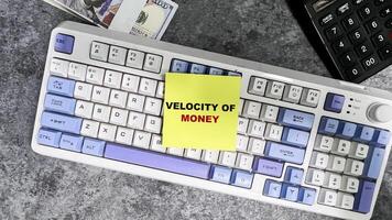 Concept of Velocity of Money write on sticky notes isolated on Wooden Table. photo