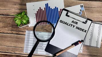 Concept of Air Quality Index write on paperwork isolated on Wooden Table. photo