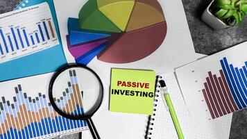 Concept of Passive Investing write on sticky notes isolated on Wooden Table. photo