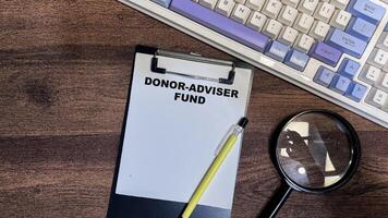 Concept of Donor-Adviser Fund write on paperwork isolated on Wooden Table. photo