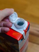 new screw cap a milk Carton with Close-Up View of Hand and Cap Design. High quality photo
