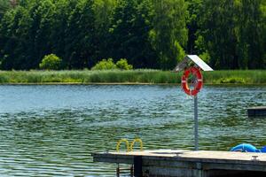 a dock with a life preserver and a red and white life preserver photo