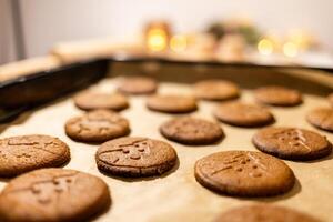a tray of cookies on a table with candles, gingerbread cookies photo
