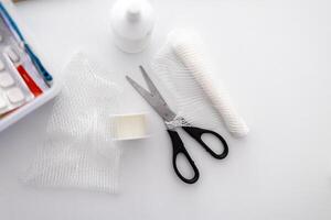 a pair of scissors, a box of bandages, and a box of gauze photo