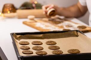a man is making cookies on a baking sheet photo