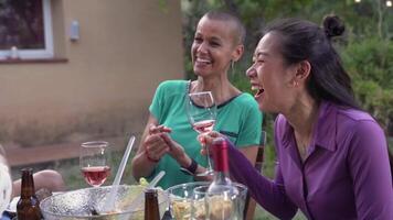 Happy friends laughing with big smile around the table in a summer diner. Smiling people eating at house patio. Smiles, cheerfulness concept. video